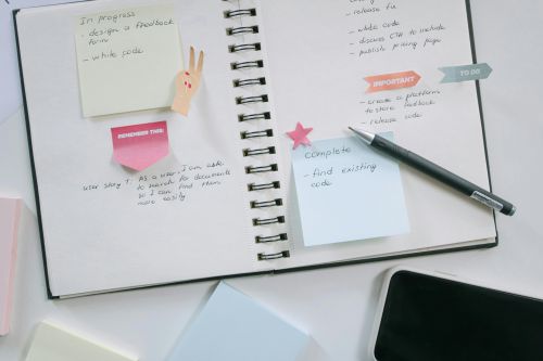 A modern workspace with a notebook, smartphone, and sticky notes emphasizing productivity and organization.