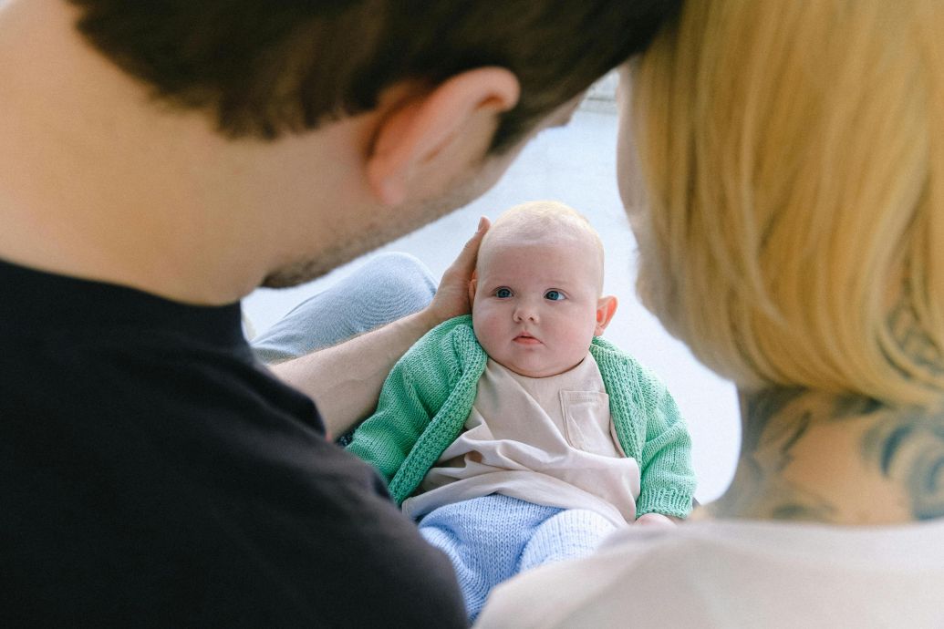 A tender moment of parents lovingly gazing at their baby in a cozy home setting.